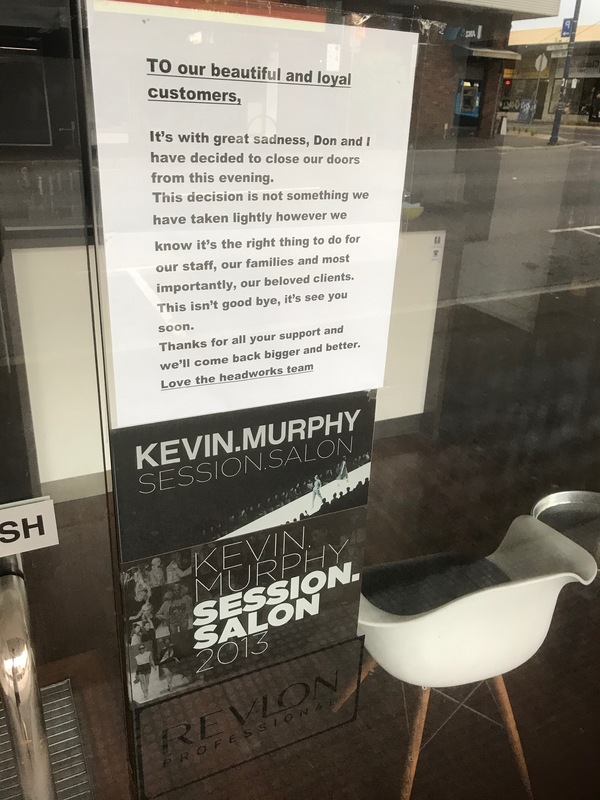A sign in front of a salon about the business closing. 