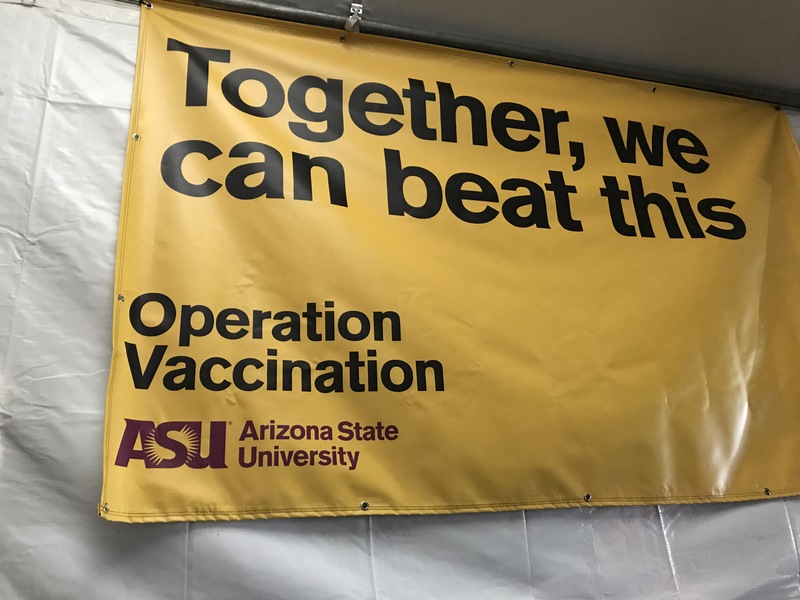 This is a picture of a yellow ASU banner in support of vaccination against COVID-19. The banner reads "Together, we can beat this. Operation Vaccination, Arizona State University."