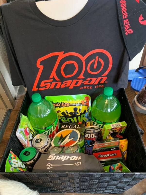 Picture of a gift basket given to a graduating high school student containing various foods, drinks, and clothing. 