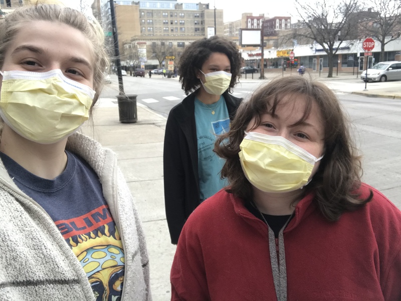 Three people with masks posing for a picture. 