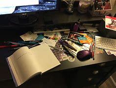 This is a picture of a desk covered in notebooks, pens, and pencils. 