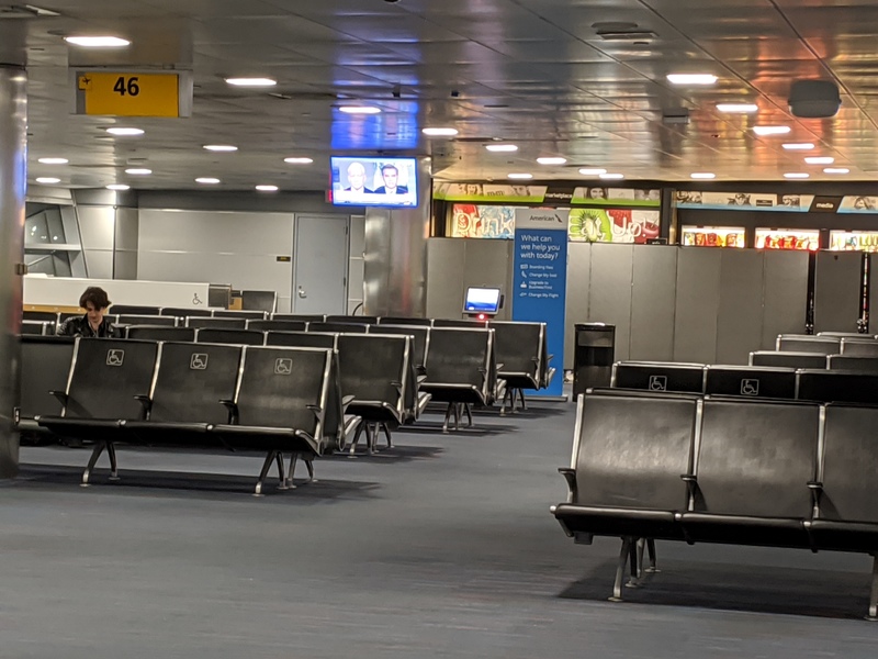 A person is sitting alone in a airport terminal. 