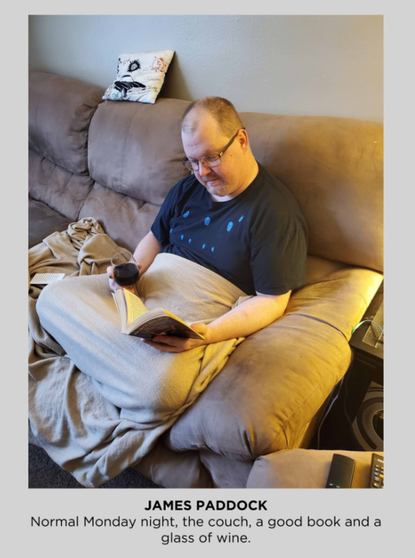 A photo of a man reading on a couch. 
