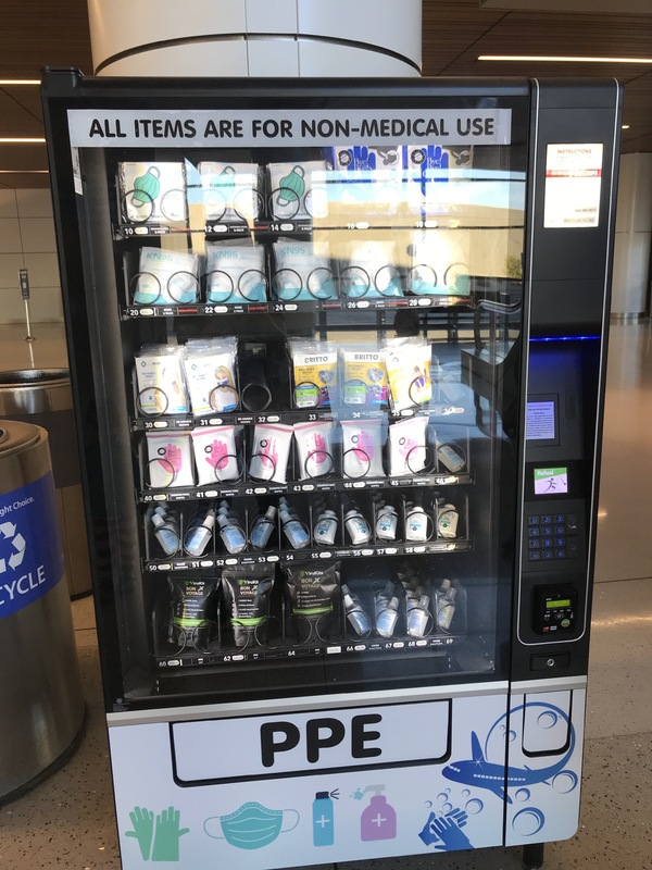 This is a picture of a vending machine which dispenses COVID-19 prevention items. Words pasted to the machine read: "All items are for non-medical use", and "PPE". 