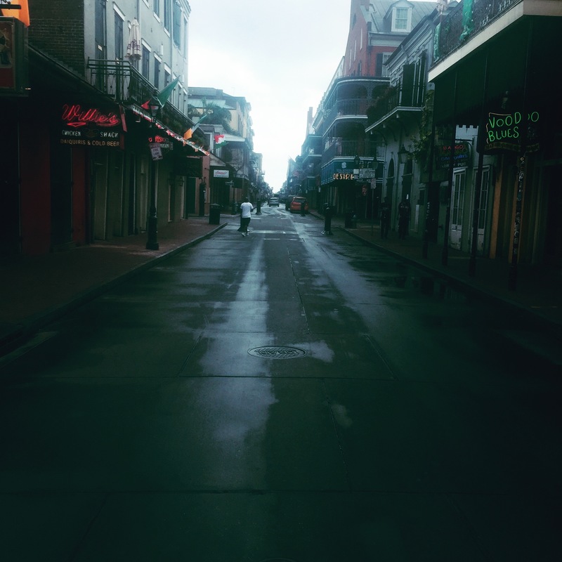 Bourbon street with only a single person walking down it. 