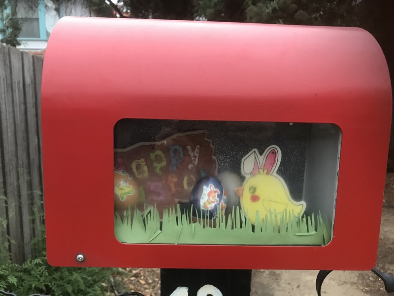 A red letterbox with a cardboard chick, two easter eggs, and a message that says "Happy Easter" in it. 