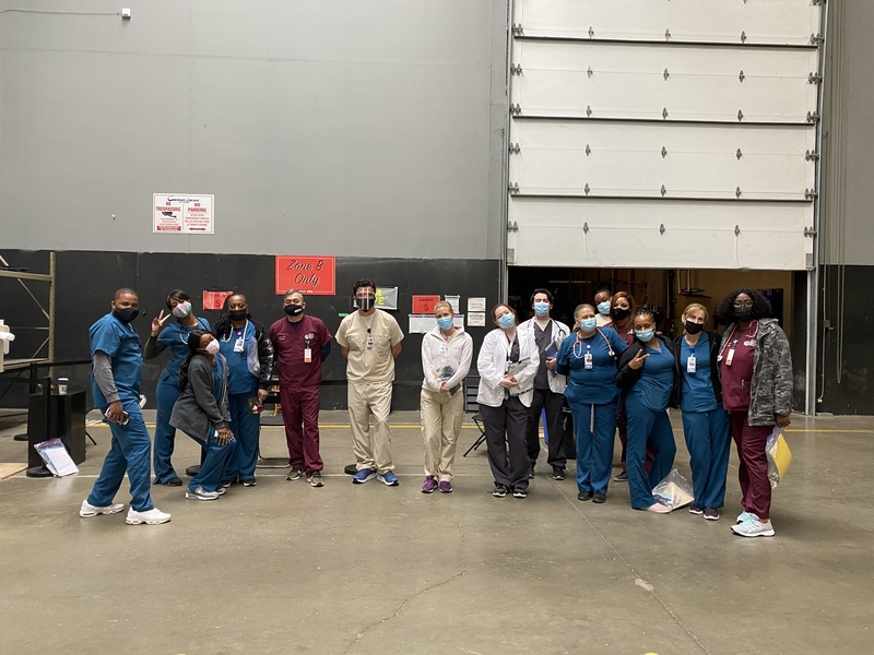 This is a picture taken of a group of healthcare workers posing for a photo while wearing face masks. 