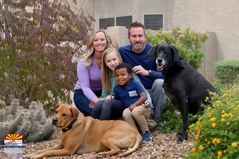 A family posing with two dogs. 