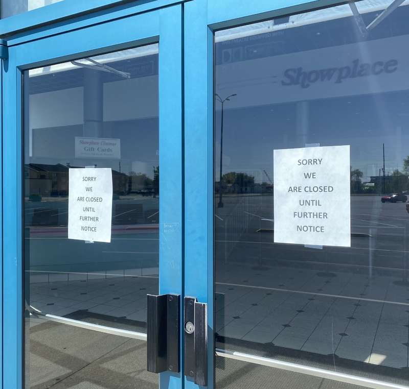 Photo of two signs on a business door reading "sorry we are closed until further notice".