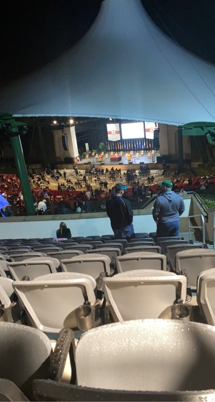 This is a picture taken of a graduation stage from the back of a large seating area, looking down into the stage area below. 