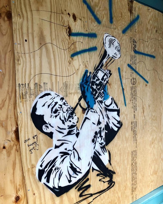 Street art of a man playing an instrument. 