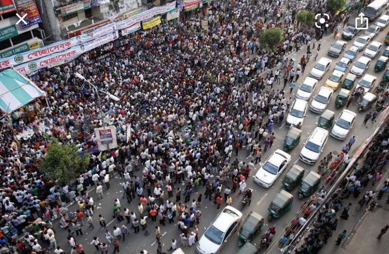 A crowd of people gathered in the street. 