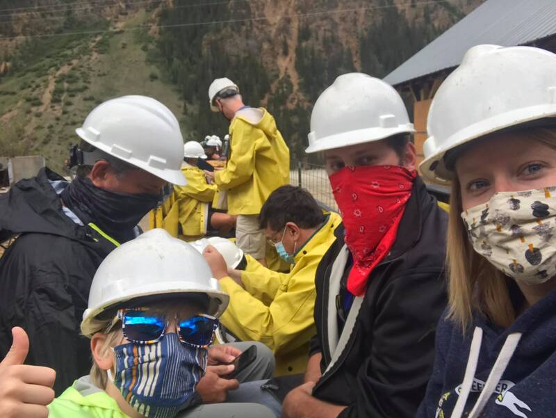 A picture of a group of people wearing bandanas and face masks to protect them from COVID-19 while outside. 