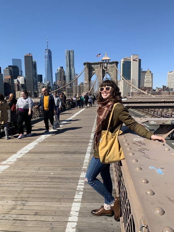 a woman in sunglasses smiling on a bridge