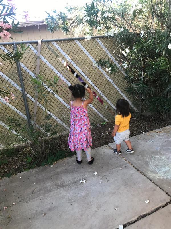 Two kids by a fence. 
