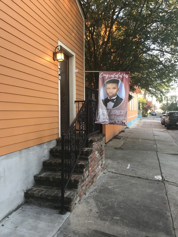 Brick stair case leading to a front door that has a banner with a senior photo and text, "Congratulations: Tyler Jones: Class of 2020: McKinley"