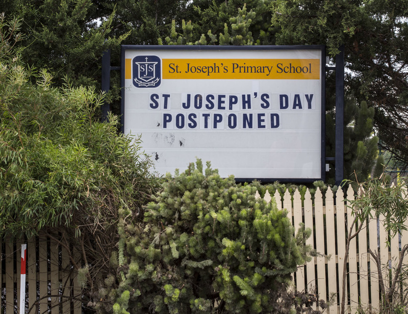 A school sign for St. Joseph's Primary School says: ST JOSEPH'S DAY POSTPONED