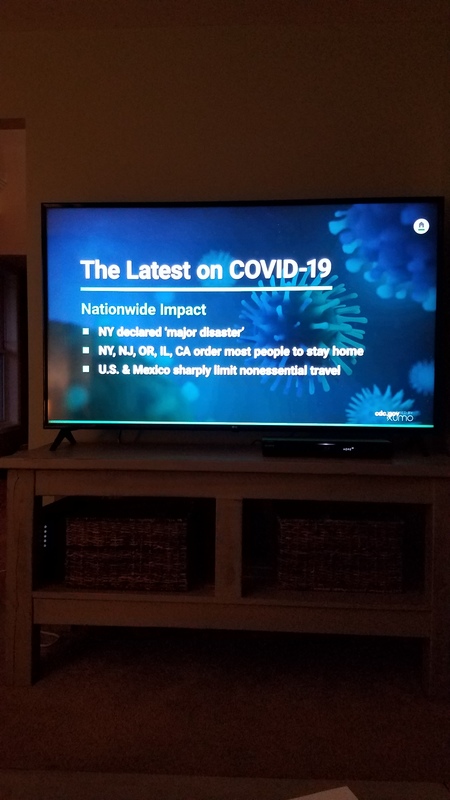 A television with the latest updates on COVID-19 being displayed. 