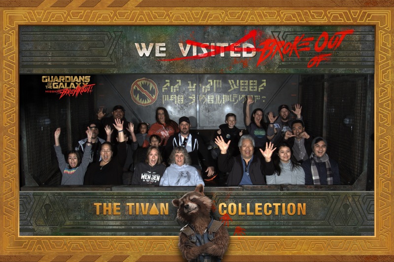 This is a picture taken at Disneyland on the Guardians of the Galaxy ride. A group of people are shown raising their hands in excitement, and the picture is framed, with a caption on it saying "We broke out of the Tivian Collection". 
