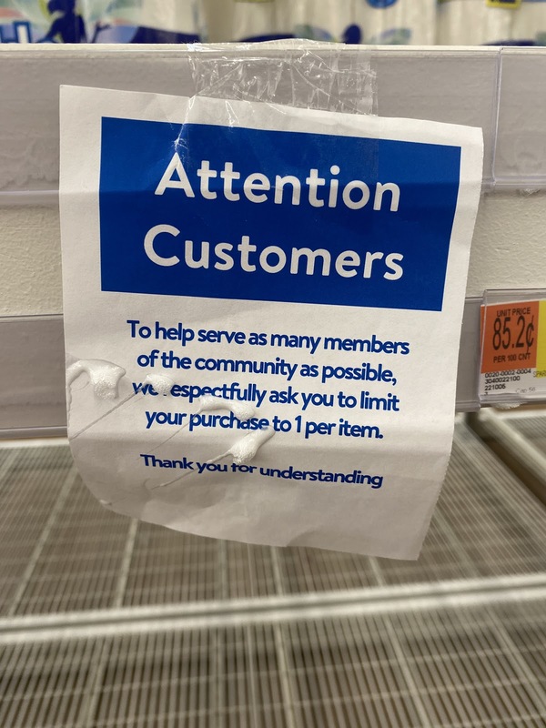A sign at Walmart that says "Attention Customers, to help serve as many members of the community as possible, we respectfully ask you to limit your purchase to 1 per item."