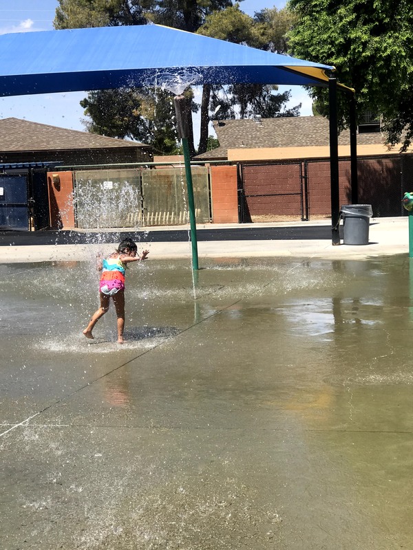 A child playing at a splash pad. 