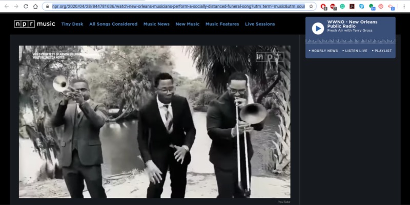 Screenshot of "NPR Music: WWNO - New Orleans Public Radio: Fresh Air with Terry Gross" with a black and white photo of three musicians in suits and ties: one playing trumpet (left), one playing trombone (right), and the other is singing (middle). There is foliage behind them. 