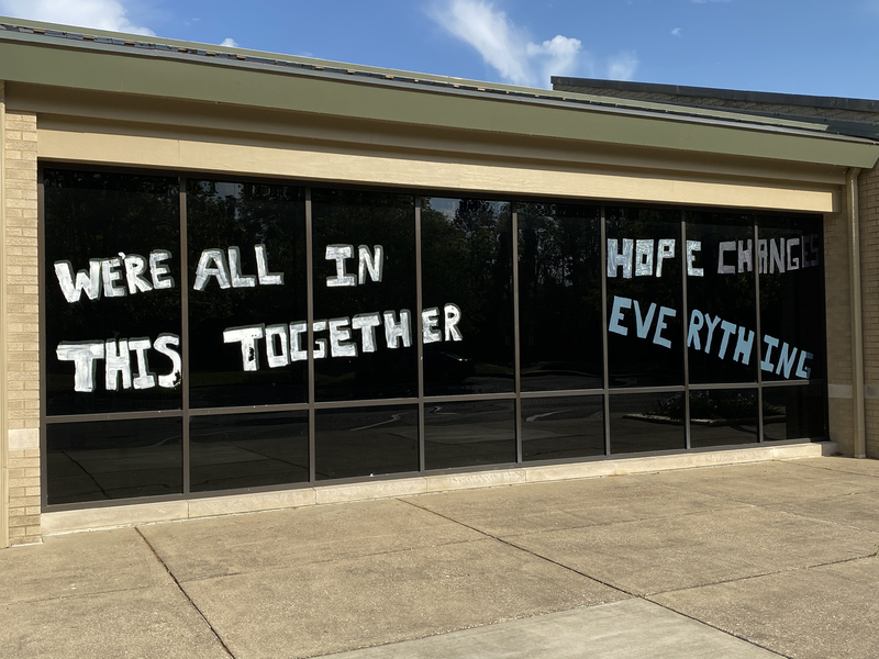 Window writing reading "We're All In This Together. Hope Changes Everything".