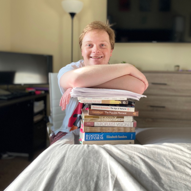 A person leaning on a stack of books. 