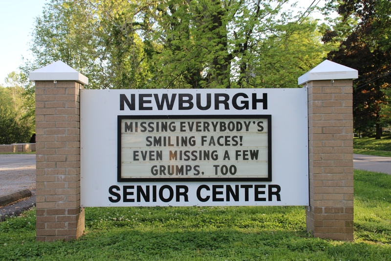 A senior center sign reading "Missing Everybody's Smiling Faces! Even Missing A Few Grumps, Too".