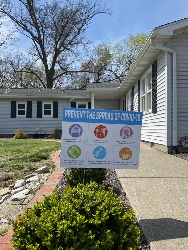 A yard sign with COVID-19 protocols. 