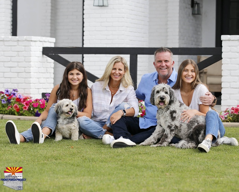 A family photo of four people and two dogs. 