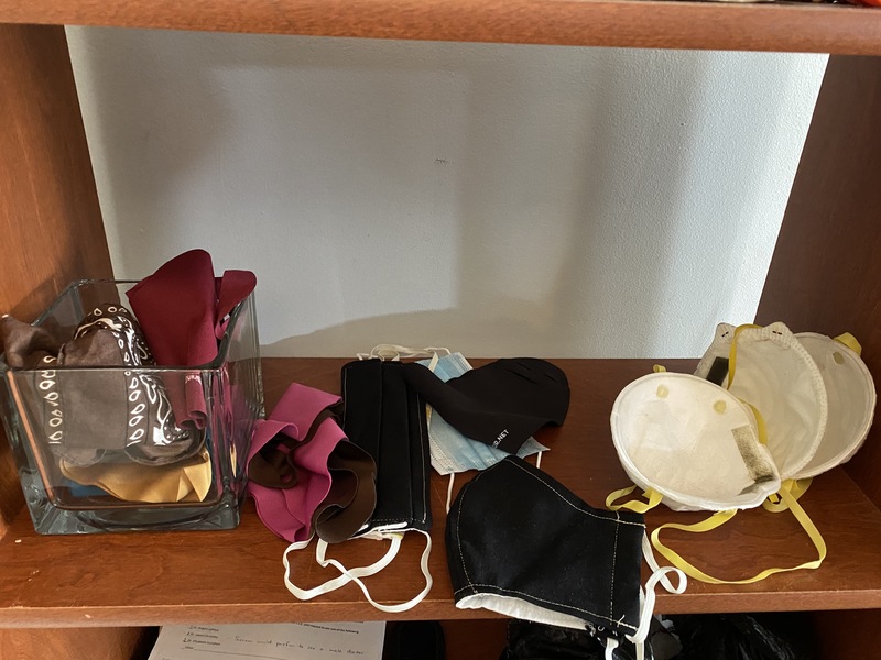 Image of various kinds of masks sitting on a shelf.