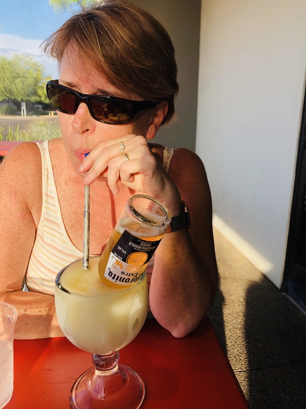 Photo of a woman drinking outside.
