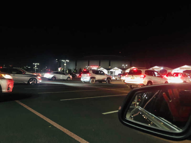 Several lanes of cars at night for drive-thru COVID-19 vaccination.