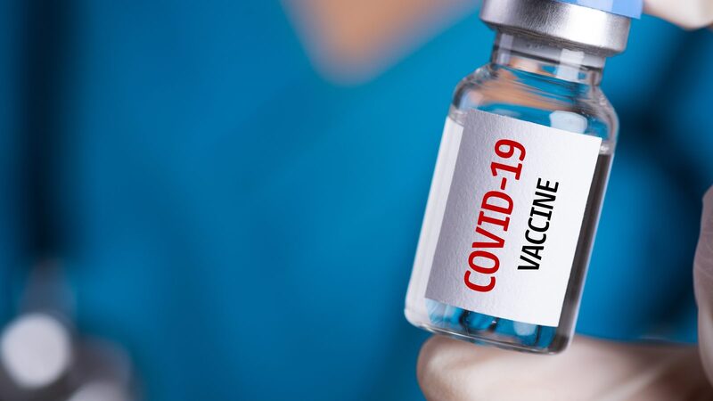 This is an image of a small glass bottle  labeled "COVID-19 Vaccine".