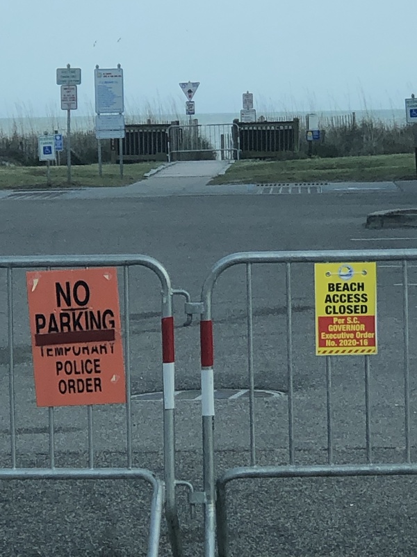 A gate with a sign that reads "beach access closed". 