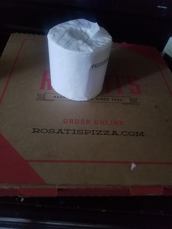 Toilet paper on top of a pizza box. 