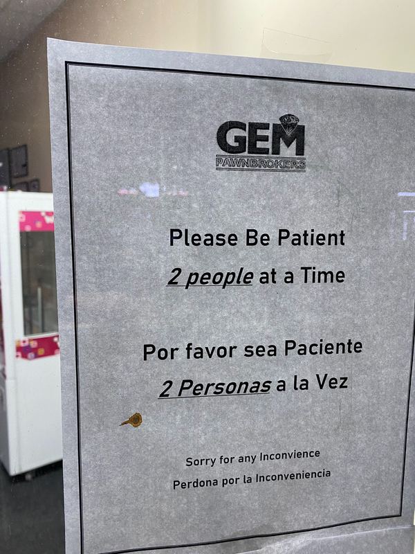 Sign for "GEM PAWNBROKERS" with text, "Please Be Patient: 2 people at a Time: Por favor sea Paciente: 2 Personas a la Vez: Sorry for any Inconvience: Perdona por la Inconveniencia"