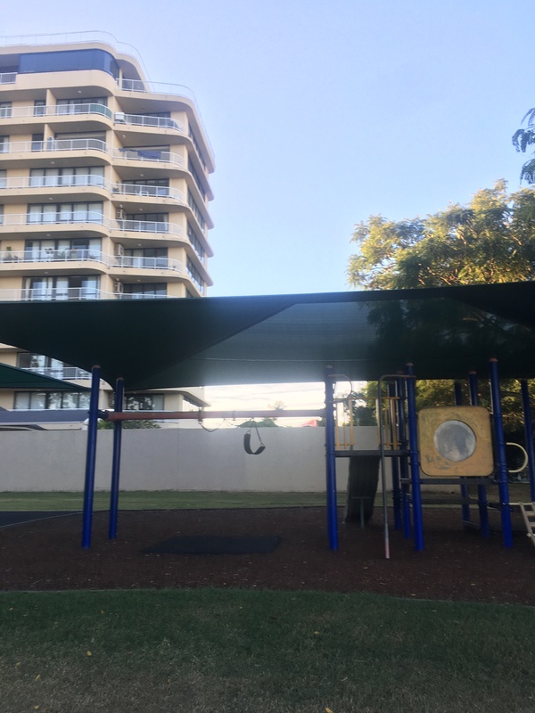 This is a picture taken of a playground, where the swing sets have been modified to prevent people from using them due to the risk of contracting COVID-19. 