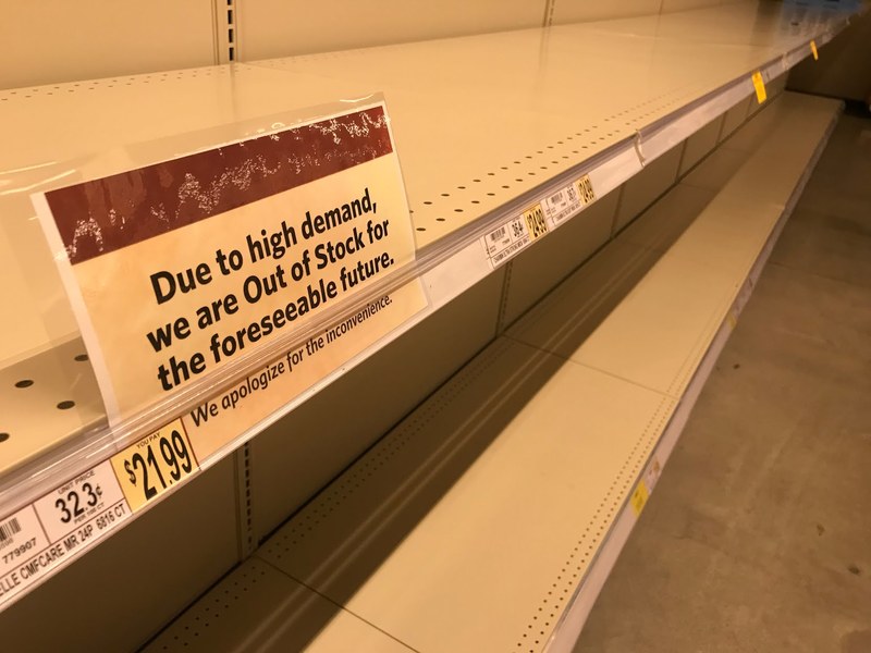 An empty row of shelves at Wegman's that has a sign up against the shelf that says: Due to high demand, we are Out of Stock for the foreseeable future. We apologize for the inconvenience. 