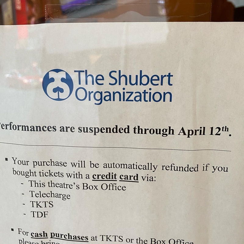 A white sign that is headed by The Shubert Organization is tapped on the inside of glass that says Performances are suspended through April 12th. 