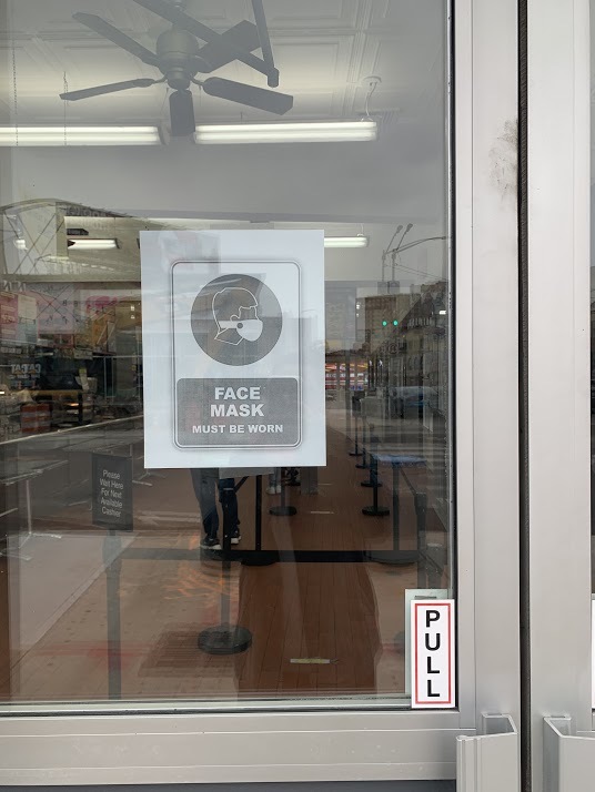 a sign on a glass door telling people masks are required