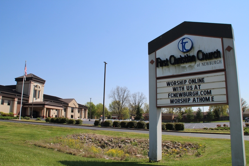 A church sign reading "Worship online with us at fcnewburgh.com worship at home".