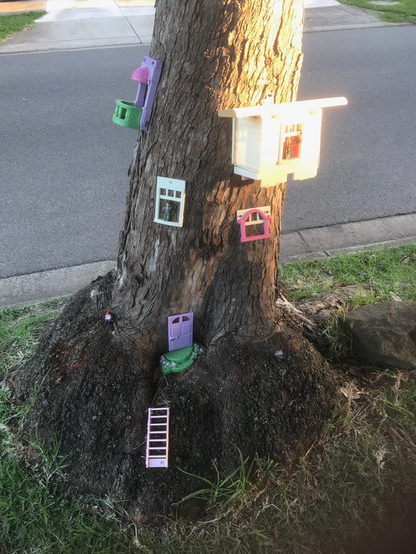 Toys on the side of a tree. 