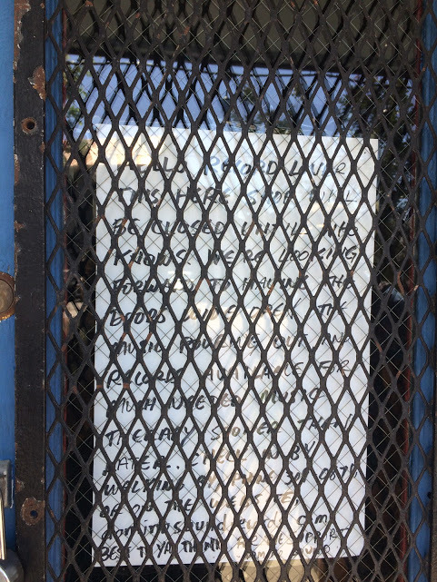 A closed sign on a grated door. 