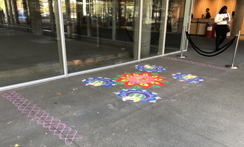 This is a picture of drawings of flowers made in chalk on a sidewalk. 