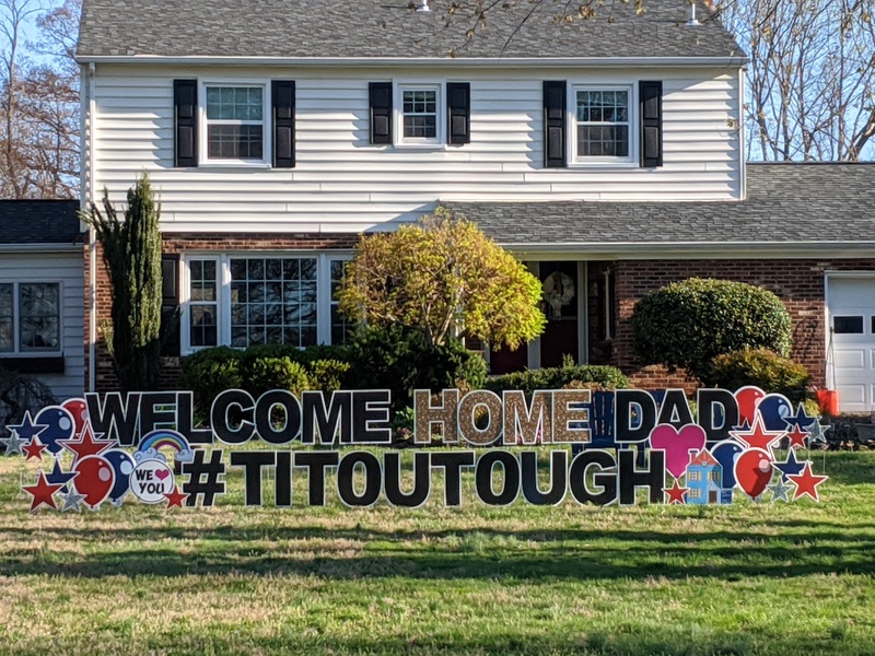 A yard sign in front of a house says: "Welcome Home Dad #Titoutough"