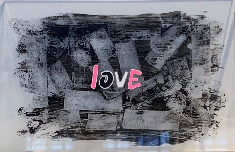 This is a picture of an abstract graphic. Black and gray bars spread over a background, while the word "love" is juxtaposed over it. 
