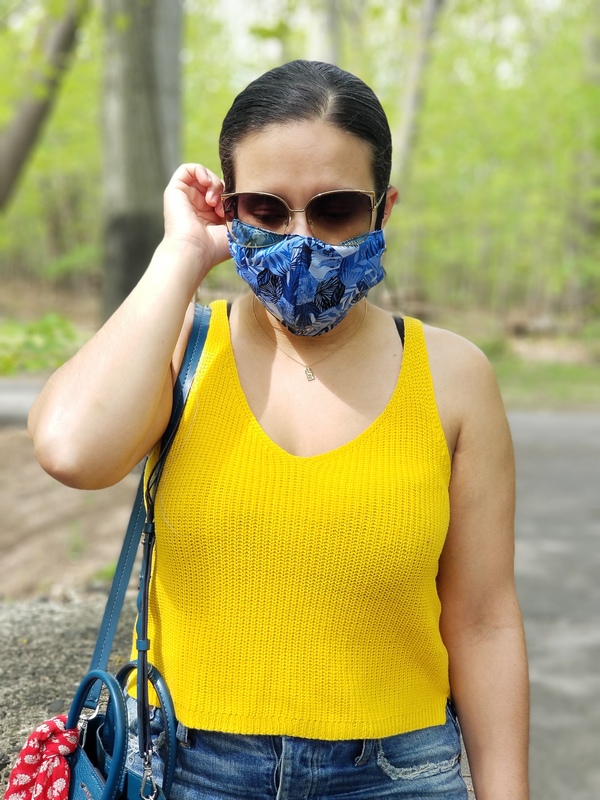 A person in a yellow shirt with a blue mask on. 