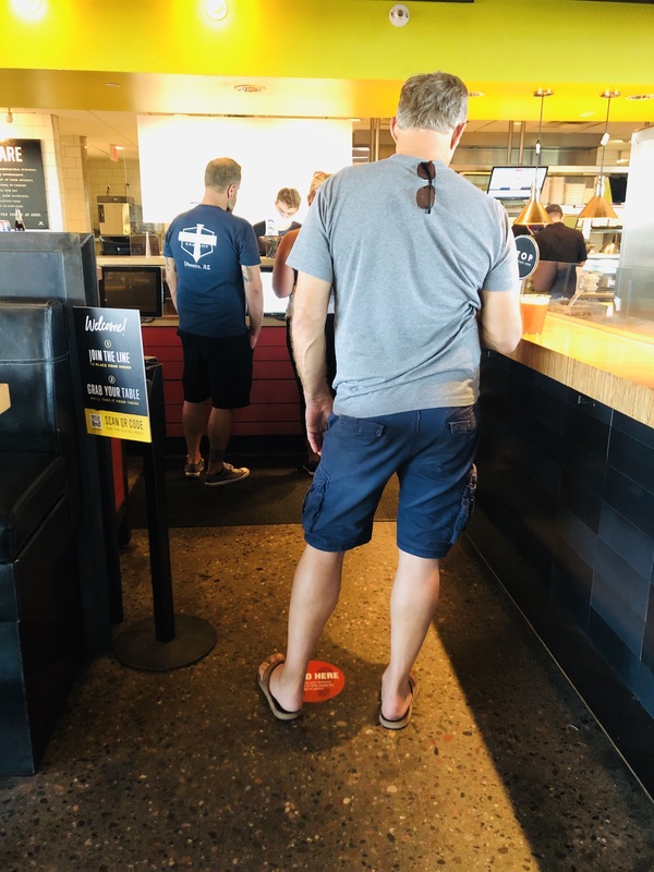 Photo of a man standing in line at a restaurant.
